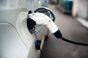 Charging an electric car with the power cable supply plugged in.